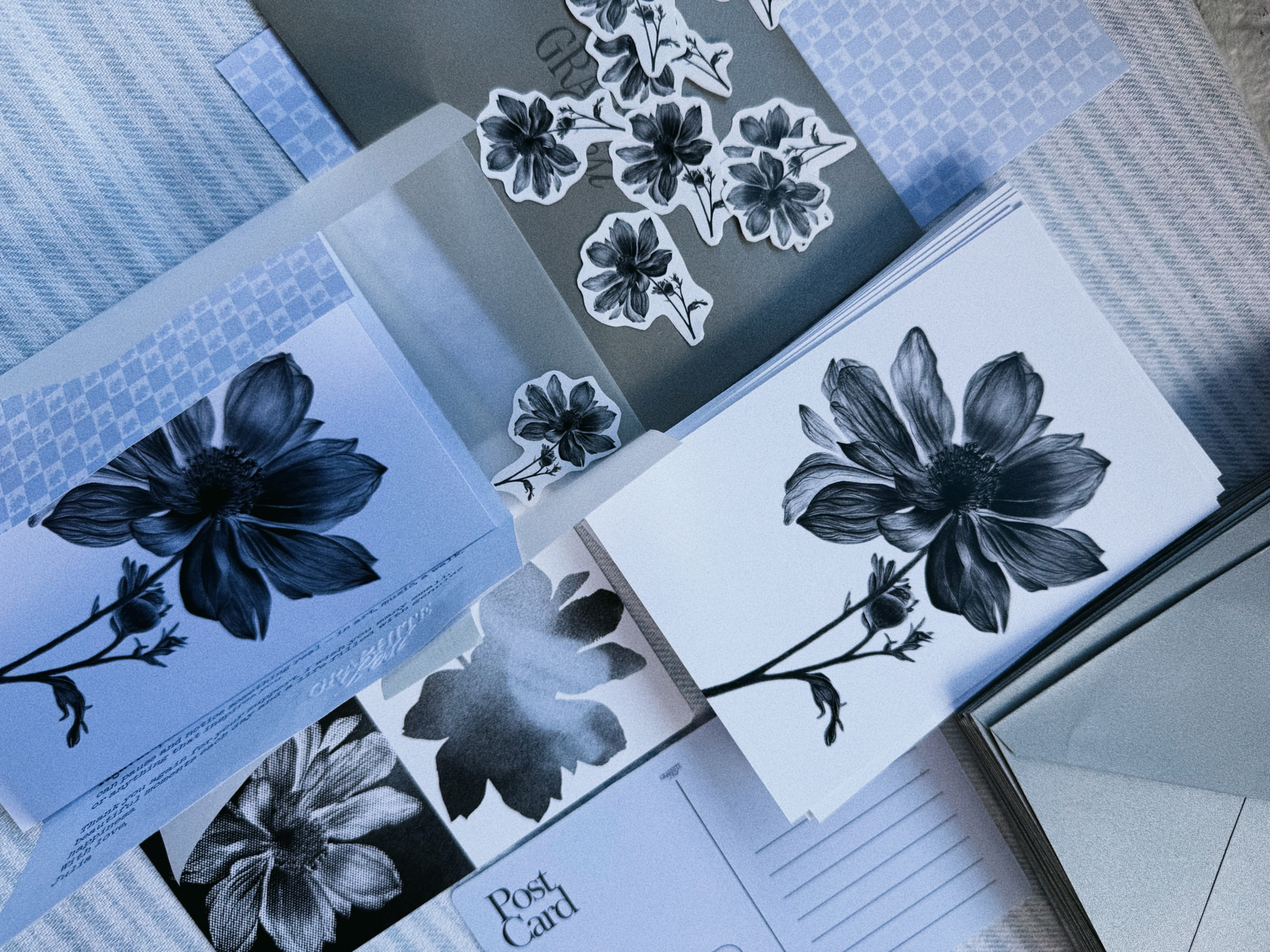 Graphite Post monthly contents spread overhead — prints, stickers and postcard