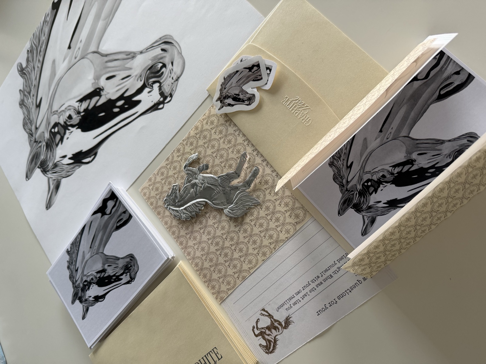 Graphite Post horse collection — prints, stickers and envelope angled flatlay on desk