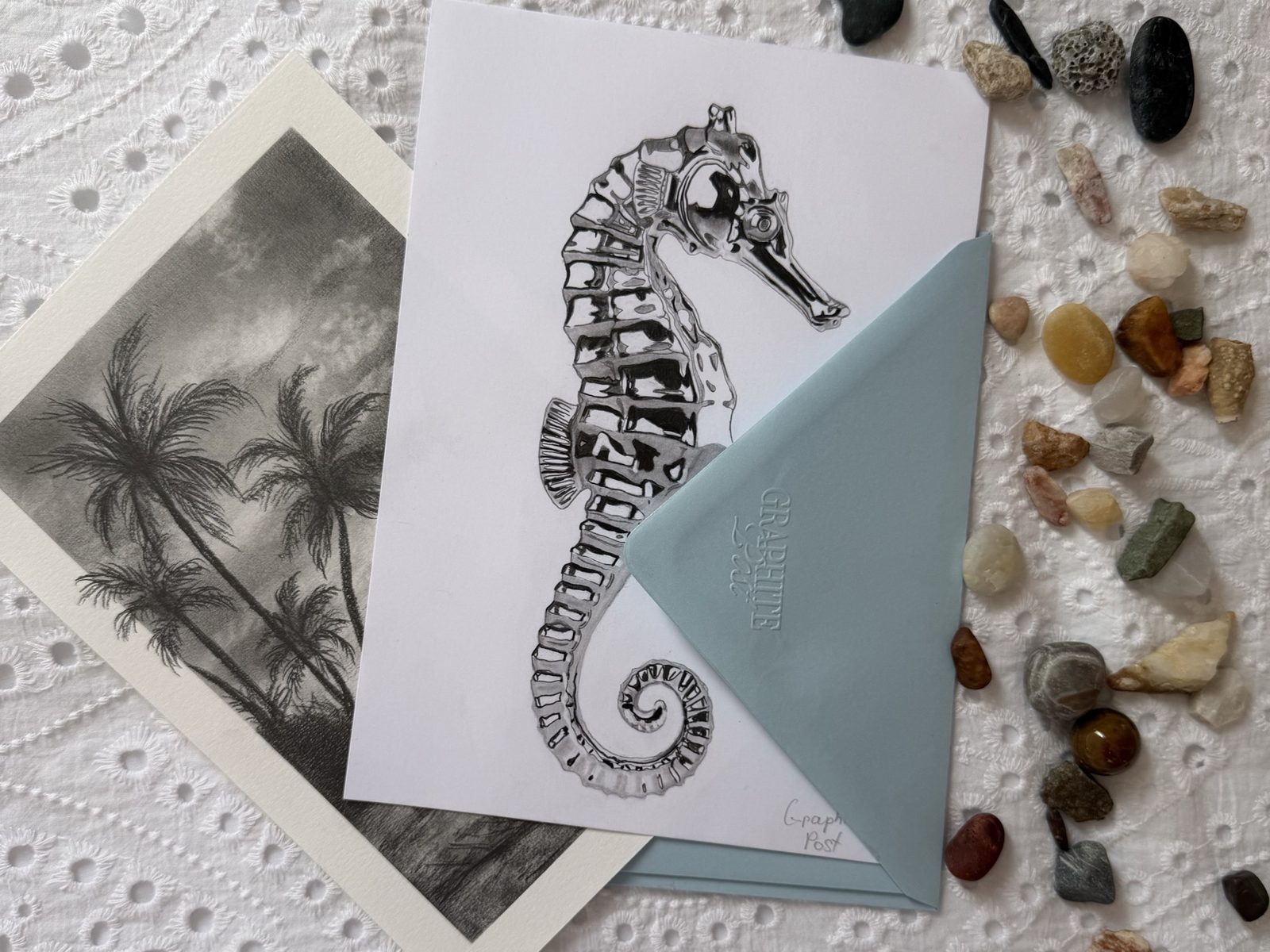 Graphite Post seahorse collection — package contents spread with prints, envelope and beach stones